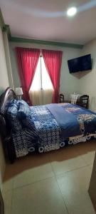 1 dormitorio con 1 cama y una ventana con cortinas rojas en Casa Serena, en Guayaquil