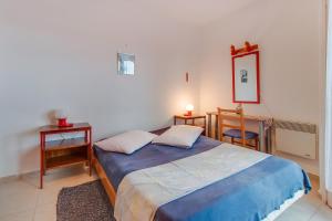 a bedroom with a bed and two tables and a mirror at Apartments by the sea Nerezine, Losinj - 2516 in Nerezine