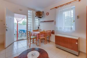 eine Küche und ein Esszimmer mit einem Tisch und Stühlen in der Unterkunft Apartments by the sea Nerezine, Losinj - 2516 in Nerezine