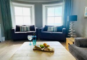 a living room with a table with a glass of wine at Pirates Place Ventnor Esplanade Beach and Sea Views in Ventnor