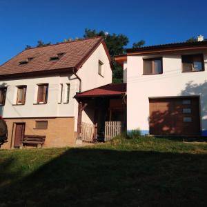 a large white house with a large garage at Vinný sklep Kovárna in Rohatec