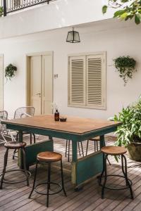 a table and stools on a patio with a table and chairs at Brown Feather Hotel in Seminyak