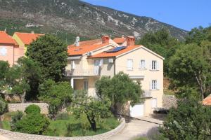 a large house in the middle of a mountain at Apartment Nerezine 2518c in Nerezine