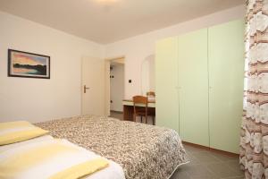 a bedroom with a bed and a desk at Apartment Nerezine 2518c in Nerezine