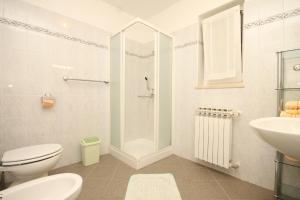 a bathroom with a shower and a toilet and a sink at Apartment Nerezine 2518c in Nerezine