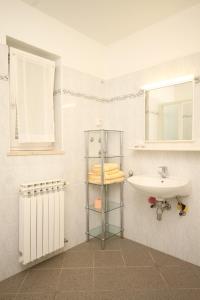 a bathroom with a sink and a toilet and a mirror at Apartment Nerezine 2518c in Nerezine