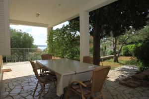 a patio with a table and chairs on a porch at Apartments with a parking space Nerezine, Losinj - 2518 in Nerezine
