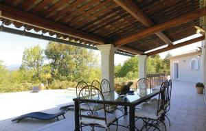 a patio with a table and chairs under a wooden roof at 4 Bedroom Awesome Home In Apt in Apt