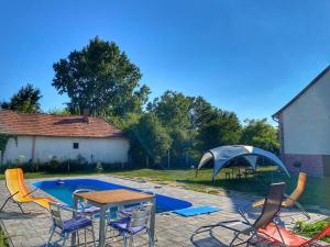 a patio with a table and chairs next to a pool at River House - Luxury house on the border of the Tisza River in Ároktő
