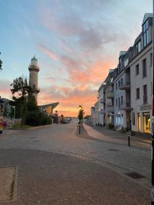 瓦爾內明德的住宿－Ferienwohnungen Alexandrinenstraße in Warnemünde，街道边的灯塔,有建筑物