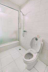 a white bathroom with a toilet and a shower at The Salak Style Hotel in Denpasar +26 photos