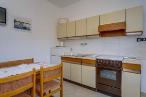 a kitchen with a table and a stove top oven at Apartments by the sea Nerezine, Losinj - 2519 in Nerezine