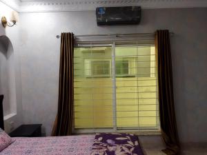 a bedroom with a window with a blind at Furnished Private Ground Floor - Pasha House in Lahore