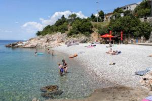 un gruppo di persone in acqua su una spiaggia di Apartments with a parking space Senj - 16747 a Senj