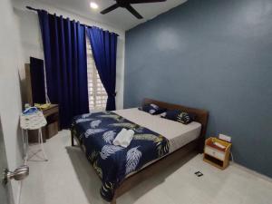a bedroom with a bed with blue walls and blue curtains at Alam Perdana @ Kemaman Cukai in Cukai