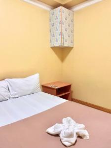 Un dormitorio con una cama con toallas blancas. en Wency Amor Hotel, en Sablayan
