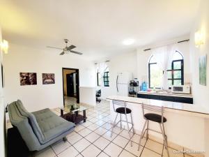 een keuken en een woonkamer met een bank en een tafel bij Quinta Suites in Cozumel