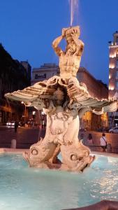 a fountain in the middle of a city at night at Trevispagna Charme Apartment Autonomous in Rome