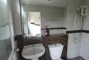 a bathroom with a toilet and a sink and a mirror at YYK Holiday Rooms in Ban Khlong Krang