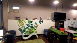 a living room with a wall with a plant mural at 花蓮阿羅國際青年旅舍民宿 in Hualien City