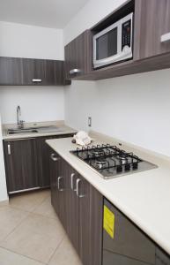 a kitchen with a stove and a microwave at Iris Studios & Apartments in Playa del Carmen