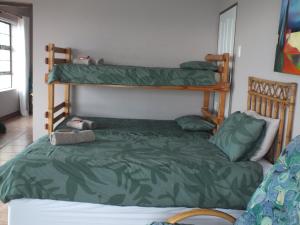 a bedroom with two bunk beds and a green comforter at Sieniesee in Mossel Bay
