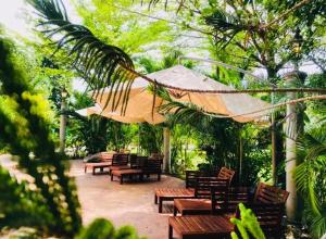 d'une terrasse avec des bancs en bois et un parasol. dans l'établissement EFM GREENLAND IPOH, à Ipoh