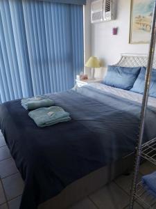 1 cama grande con sábanas azules y almohadas azules en Seafront Shack, en Port Hughes