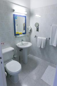 a bathroom with a toilet and a sink and a mirror at Fitosinn Hotel in Paphos
