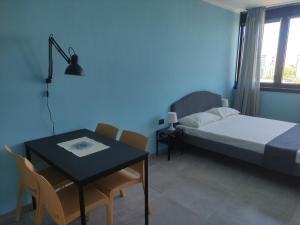 a bedroom with a table and a bed and a table and chairs at Una finestra su Savona in Savona