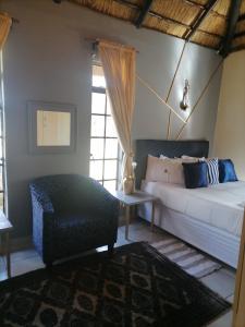 1 dormitorio con cama, sofá y mesa en Matlapeng Country Estate, en Vanderbijlpark