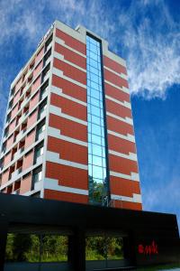 a tall red and white building with glass windows at Hotel Mak in Gabrovo