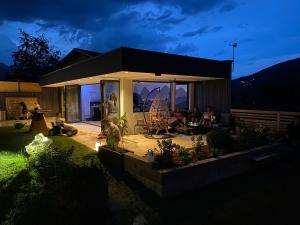 grupa ludzi siedzących w nocy na patio w obiekcie Appartements-Pension Lindenheim w Schladming