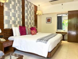 a bedroom with a large bed and a bathroom at Acron Waterfront Resort in Baga