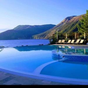 una gran piscina junto a un cuerpo de agua en Vulcano Blu Residence en Vulcano