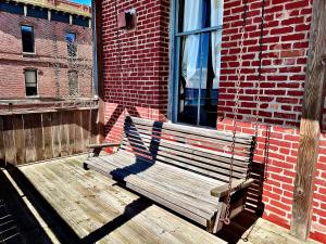 a wooden bench sitting on a porch next to a window at The Monarch Hotel in Port Townsend