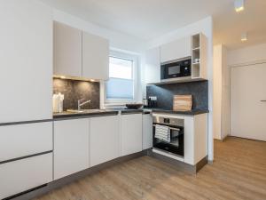 a white kitchen with white cabinets and a window at Apartment in St Georgen Salzburg near ski area in Fürstau