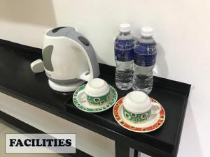a tea kettle and two bottles of water on a counter at JERANTUT HILL HOTEL in Jerantut