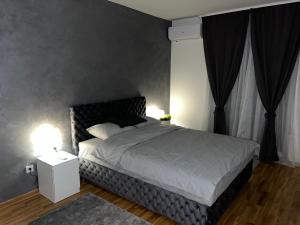 Schlafzimmer mit einem großen Bett mit einem schwarzen Kopfteil in der Unterkunft KoTa grey in Karaburma