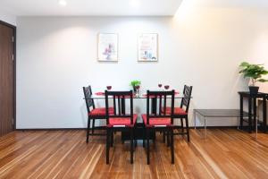 una sala da pranzo con tavolo nero e sedie rosse di The Title Rawai Beach West Wing Pool Access Aparment a Rawai Beach