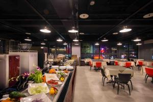 a dining room with tables and chairs and a buffet at Hotel J Taoyuan in Pingzhen