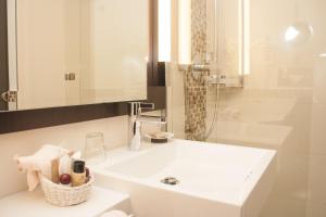 波昂的住宿－柏林豪斯酒店，白色的浴室设有水槽和淋浴。