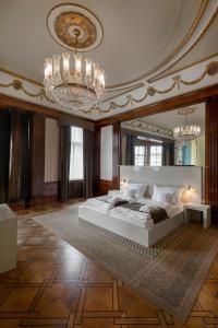 Hotel Okresní Dům في هراديك كرالوف: غرفة نوم كبيرة بسرير كبير وثريا