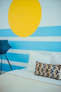 Roemah Renjana Bandung في باندونغ: غرفة نوم مع سرير مع دائرة صفراء على الحائط