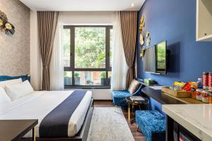 um quarto de hotel com uma cama, uma secretária e uma janela em KunKin Luxury Hotel & Apartment em Ho Chi Minh