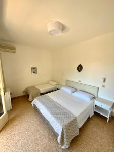a bedroom with a large white bed and two tables at Hotel Naviglio in Marina di Pietrasanta