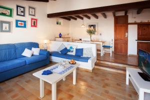 a living room with a blue couch and a table at Ancora 1 in Cala de Sant Vicenc