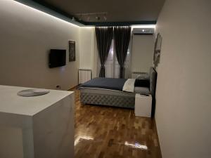 um quarto com uma cama e uma secretária num quarto em KoTa apartmani Beograd em Karaburma