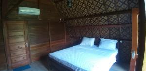 1 dormitorio con 1 cama con cabecero de madera en Villa Lumbung Ayu Sari & Spa, en Karangasem