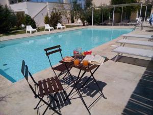 - une table avec de la nourriture à côté de la piscine dans l'établissement Masseria Agriturismo Faresalento, à Gallipoli